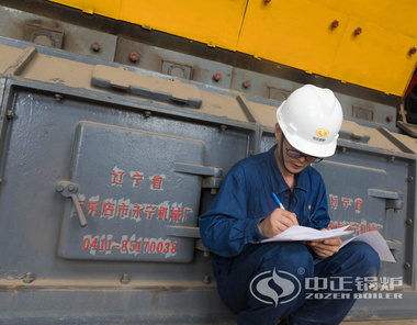 中正鍋爐售后人員認(rèn)真記錄熱水鍋爐檢測數(shù)據(jù)