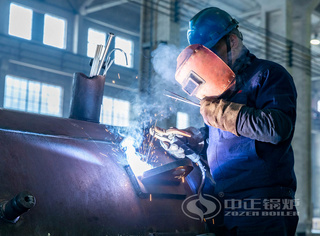 工人专注地举行锅炉壳体的焊接作业